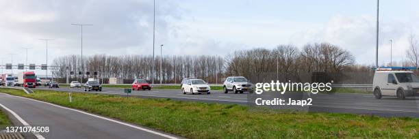 daytime traffic driving on the dutch a12 highway at harmelen - side by side car stock pictures, royalty-free photos & images