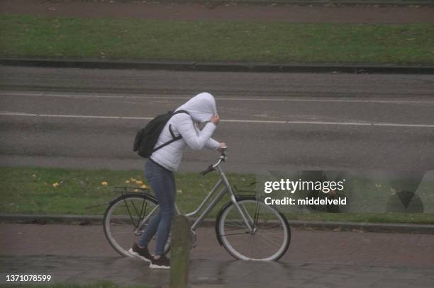 biker walking in rain and storm - limburg netherlands stock pictures, royalty-free photos & images