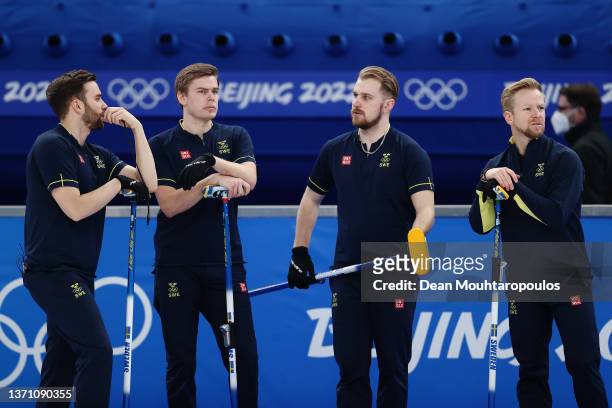 Oskar Eriksson, Christoffer Sundgren, Rasmus Wranaa and Niklas Edin of Team Sweden interact while competing against Team Canada during the Men’s...