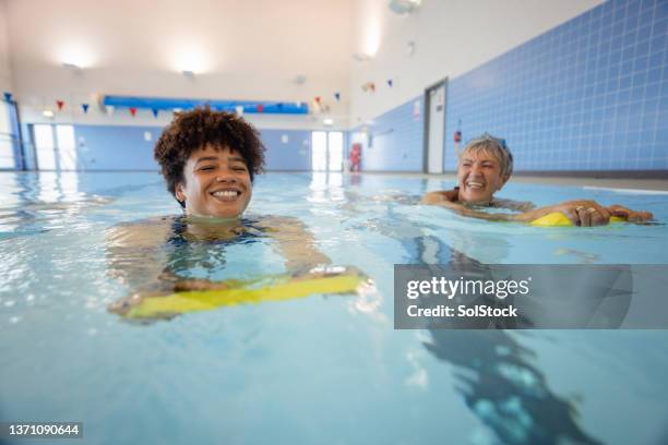 bindung beim schwimmen - lernen erwachsene stock-fotos und bilder