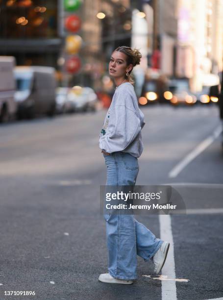 Millane Friesen is wearing a denim blue jeans and a grey hoodie and white sneaker during New Yorker Fashion Week on February 15, 2022 in New York...