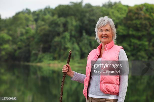 portrait of senior woman holding stick - hiking pole stock pictures, royalty-free photos & images