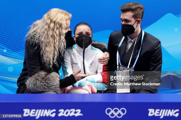 Kamila Valieva of Team ROC reacts to their score with choreographer Daniil Gleikhengauz and coach Eteri Tutberidze after the Women Single Skating...