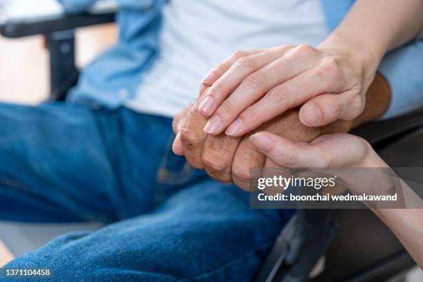 nurse holding hands with elderly patient. - ospizio foto e immagini stock