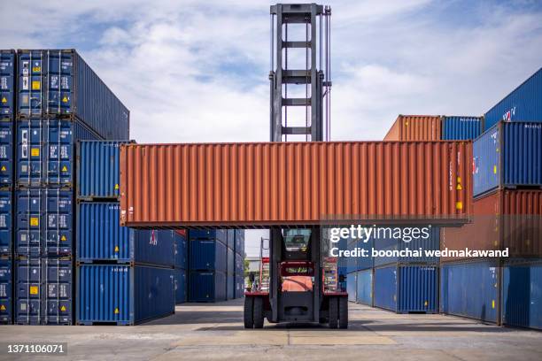forklift truck lifting cargo container in shipping yard. - box lifting technique stock-fotos und bilder