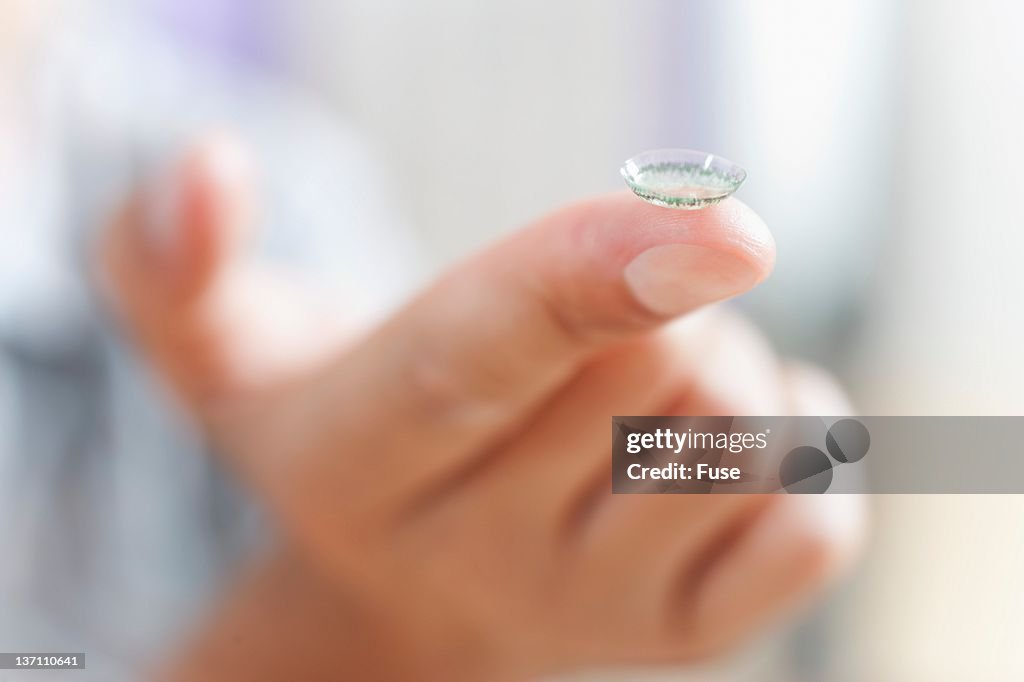 Man holding a contact lens