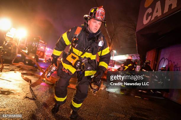 East Farmingdale, N.Y.: FDNY Fire Academy Chief Frank Leeb stretches a hose line while attempting to extinguish a fire on Route 110, in East...