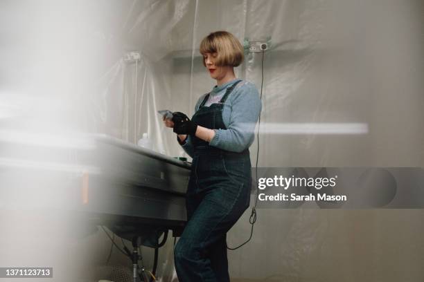 woman in studio working at machine etching glass panel - femalefocuscollection stock-fotos und bilder