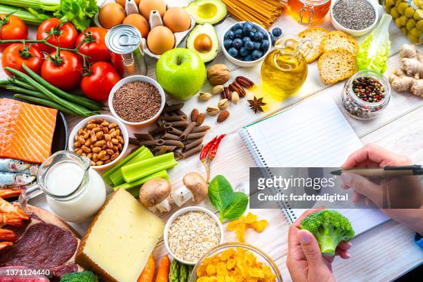 schreiben einer liste gesunder lebensmittel auf einen notizblock - cereal plant stock-fotos und bilder
