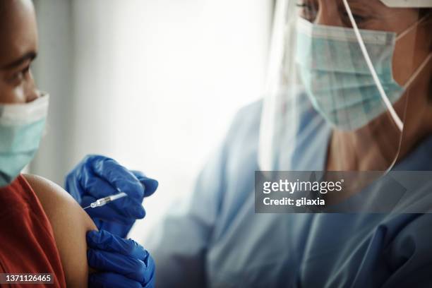 covid 19 vaccinaation. - blue glove stock pictures, royalty-free photos & images