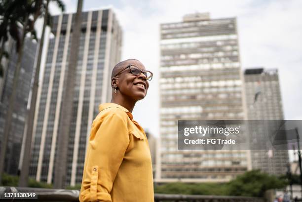 contemplative mature woman looking away in the city - woman looking away stock pictures, royalty-free photos & images