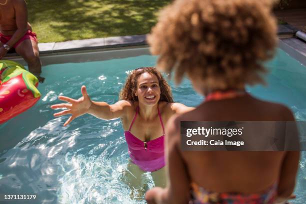 happy mother waiting for daughter to jump into arms in swimming pool - leap of faith modo di dire inglese foto e immagini stock