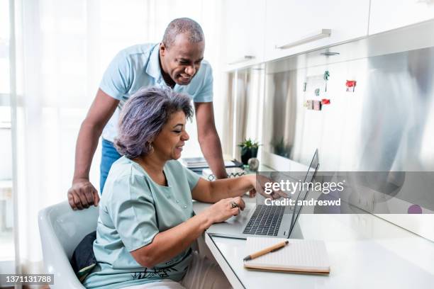 mature couple using laptop at home. - contemporary couple stock pictures, royalty-free photos & images