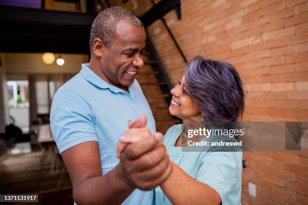 mature couple dancing at home - 50 59 years home stock pictures, royalty-free photos & images