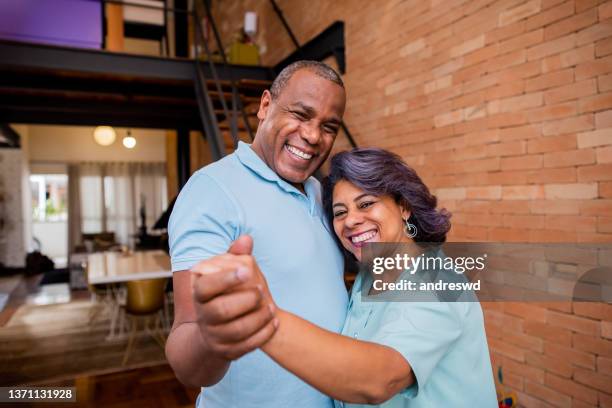 mature couple dancing at home - 50 59 years home stock pictures, royalty-free photos & images