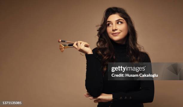 portrait of cute beautiful young woman holding makeup brushes. - maquilhador imagens e fotografias de stock