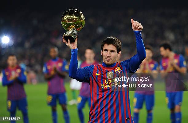 Barcelona's Argentinian forward Lionel Messi shows the Ballon d'Or Trophy before the Spanish league football match between FC Barcelona and Betis at...