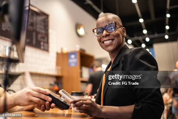 businesswoman paying with qr with mobile in a coffeeshop - app store stockfoto's en -beelden