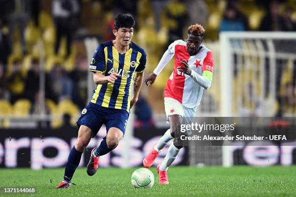 Kim Min-Jae of Fenerbahce runs with the ball from Peter Olayinka of SK Slavia Praha during the UEFA Europa Conference League Knockout Round Play-Offs...