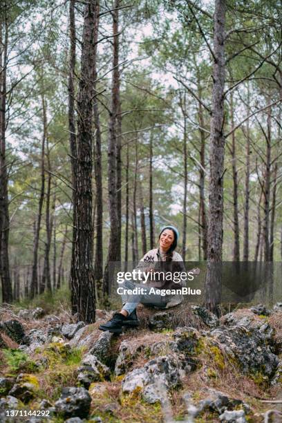 junge frau spielt ukulele im wald - ukulele stock-fotos und bilder