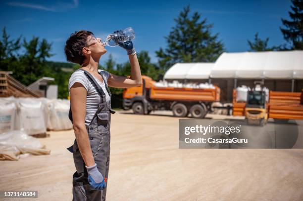 trabajadora de cuello azul sedienta en planta procesadora de mineral - calentador fotografías e imágenes de stock