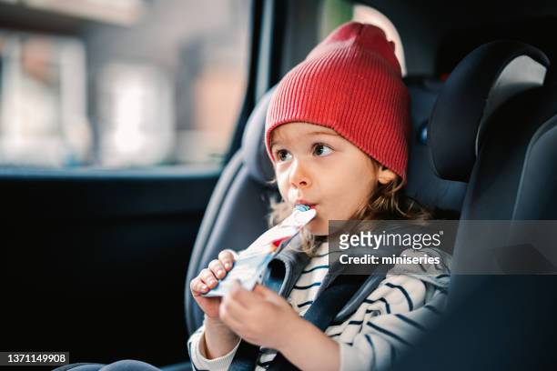 little girl drinking juice while traveling by car - drinking juice stock pictures, royalty-free photos & images