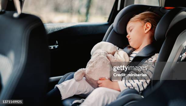 kleines mädchen, das auf reisen mit dem auto schläft - auto schlafen stock-fotos und bilder