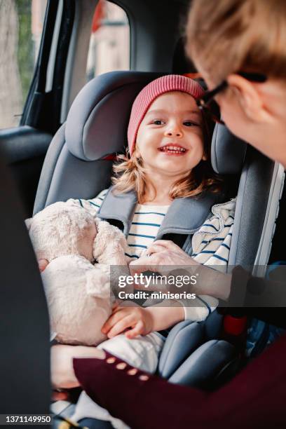 un genitore anonimo allaccia la cintura di sicurezza del suo bambino in macchina - pink belt foto e immagini stock