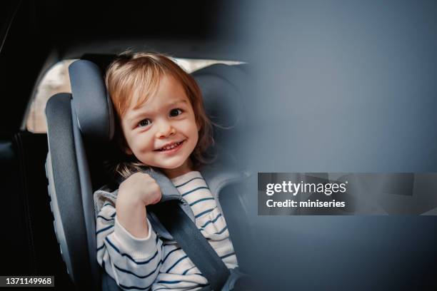 portrait of a cheerful little girl enjoy traveling by car - kid car seat stock pictures, royalty-free photos & images