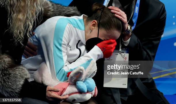 Kamila Valieva of Russia reacts to her score with coach Eteri Tutberidze and Daniil Gleikhengauz at 'Kiss and Cry' during the Women Single Skating...