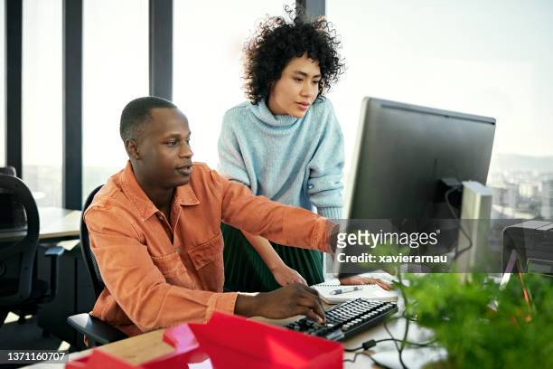 現代オフィスでプロジェクトに取り組む若いビジネスパートナー - using a computer ストックフォトと画像