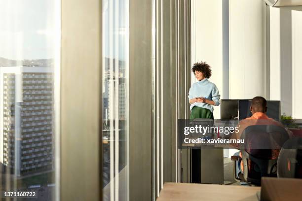 young businesswoman looking at view from modern office - man woman wondering stock pictures, royalty-free photos & images