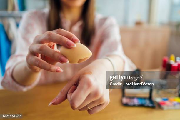 woman holding beauty blender sponge - make up foundation stock pictures, royalty-free photos & images