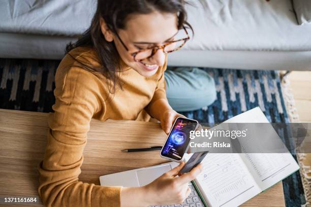 young woman using credit card to buy cryptocurrency - stock market traders stock pictures, royalty-free photos & images