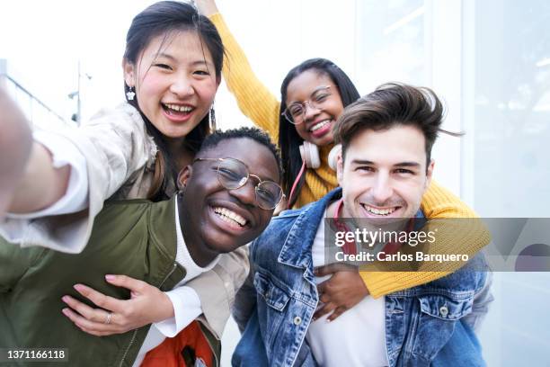 group of multiethnic student friends, celebrating the end of classes, taking a selfie together. - male student wearing glasses with friends stockfoto's en -beelden