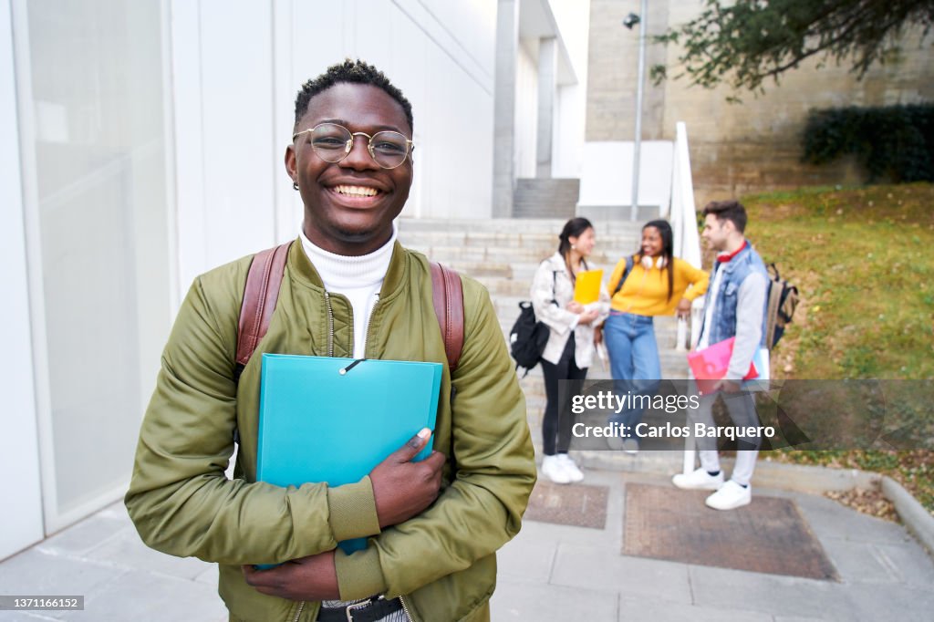 Happy African American young men looking at the camera out at the university campus.