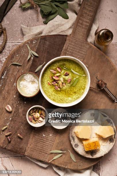 sage and pistachio pesto prepared on wooden board with parmesan cheese and olive oil - food dressing stock pictures, royalty-free photos & images