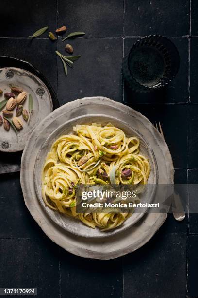 linguine pasta with sage pesto and pistachio on dark backdrop - serving dish foto e immagini stock