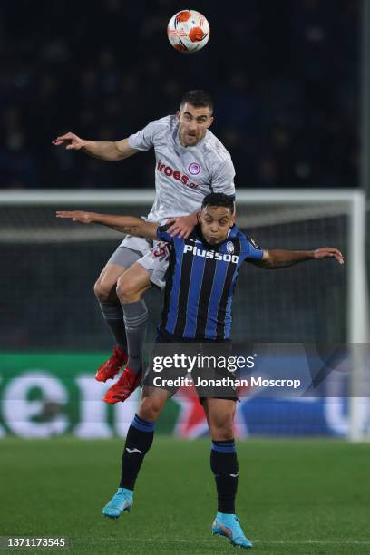 Sokratis Papastathopoulos of Olympiacos FC heads clear from Luis Muriel of Atalanta during the UEFA Europa League Knockout Round Play-Offs Leg One...