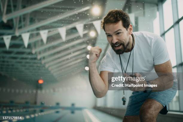 personal coach encouraging swimmer when swimming indoors in swimming pool. - sport coach fotografías e imágenes de stock