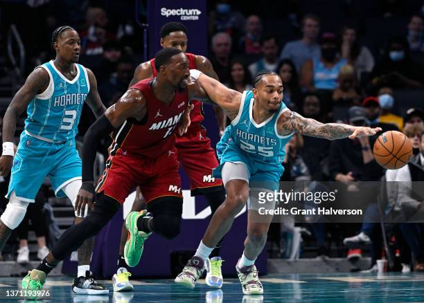 Washington of the Charlotte Hornets battles Bam Adebayo of the Miami Heat for a loose ball during the first half of their game at Spectrum Center on...