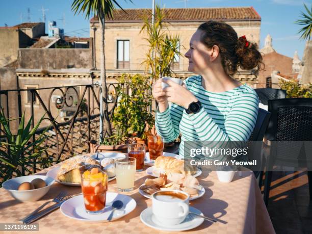 woman sitting down to a continental breakfast in sicily - catania sicily fotografías e imágenes de stock