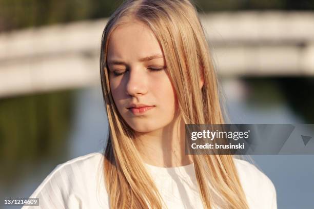 retrato al aire libre de una adolescente rubia de 15 años con el pelo largo en camiseta blanca - 15 year old blonde girl fotografías e imágenes de stock