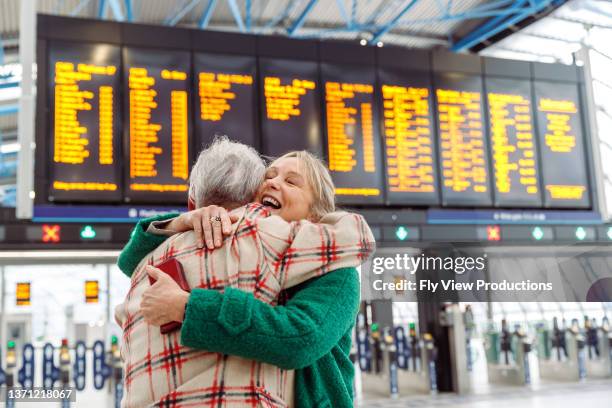 réunion heureuse d’un couple de personnes âgées à l’aéroport - arrivée photos et images de collection