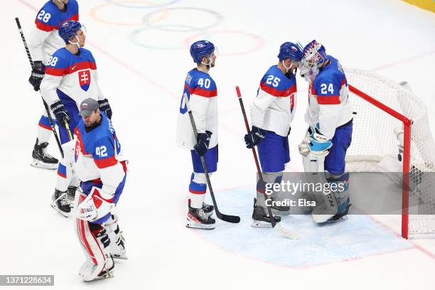 Peter Zuzin of Team Slovakia bumps the mask of Patrik Rybar with his helmet after their 2-0 loss in the Men's Ice Hockey Playoff Semifinal match...