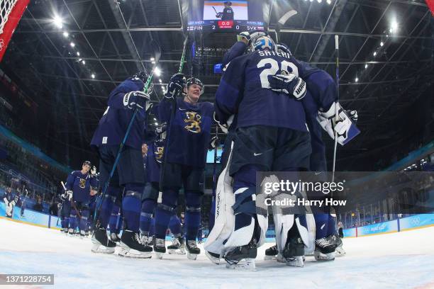 Goaltender Harri Sateri of Team Finland is congratulated by teammates after their 2-0 win in the Men's Ice Hockey Playoff Semifinal match between...