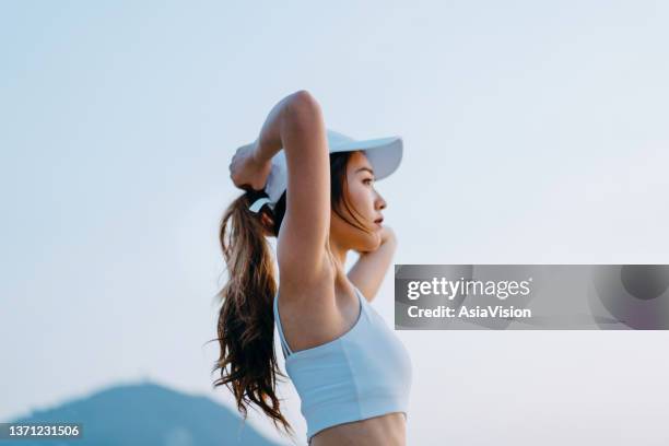 side profile of confident young asian sports woman in sportswear looking away with determination, getting ready to working out outdoors in the city. youth culture. girl power. active lifestyle. health and fitness concept - asian woman fitness stock pictures, royalty-free photos & images