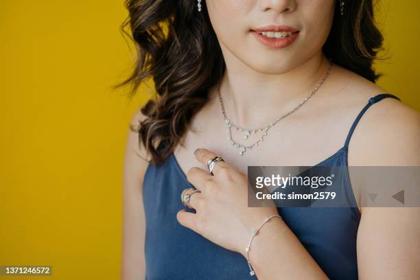 portrait of beautiful asian woman dressed in a posh jewelry set of diamond ring, necklace, bracelet and earrings - skin diamond stock pictures, royalty-free photos & images