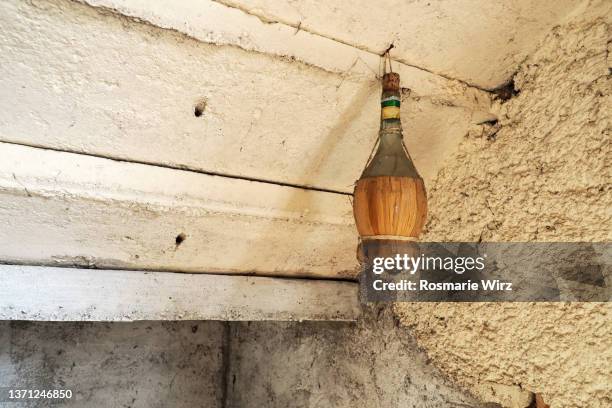 chianti flask hung on old wall - chianti streek stockfoto's en -beelden