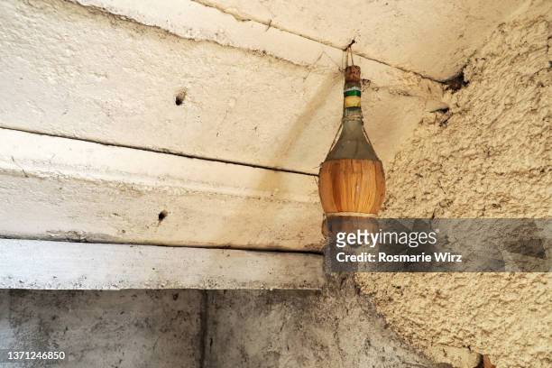 chianti flask hung on old wall - covered food with wine stock pictures, royalty-free photos & images